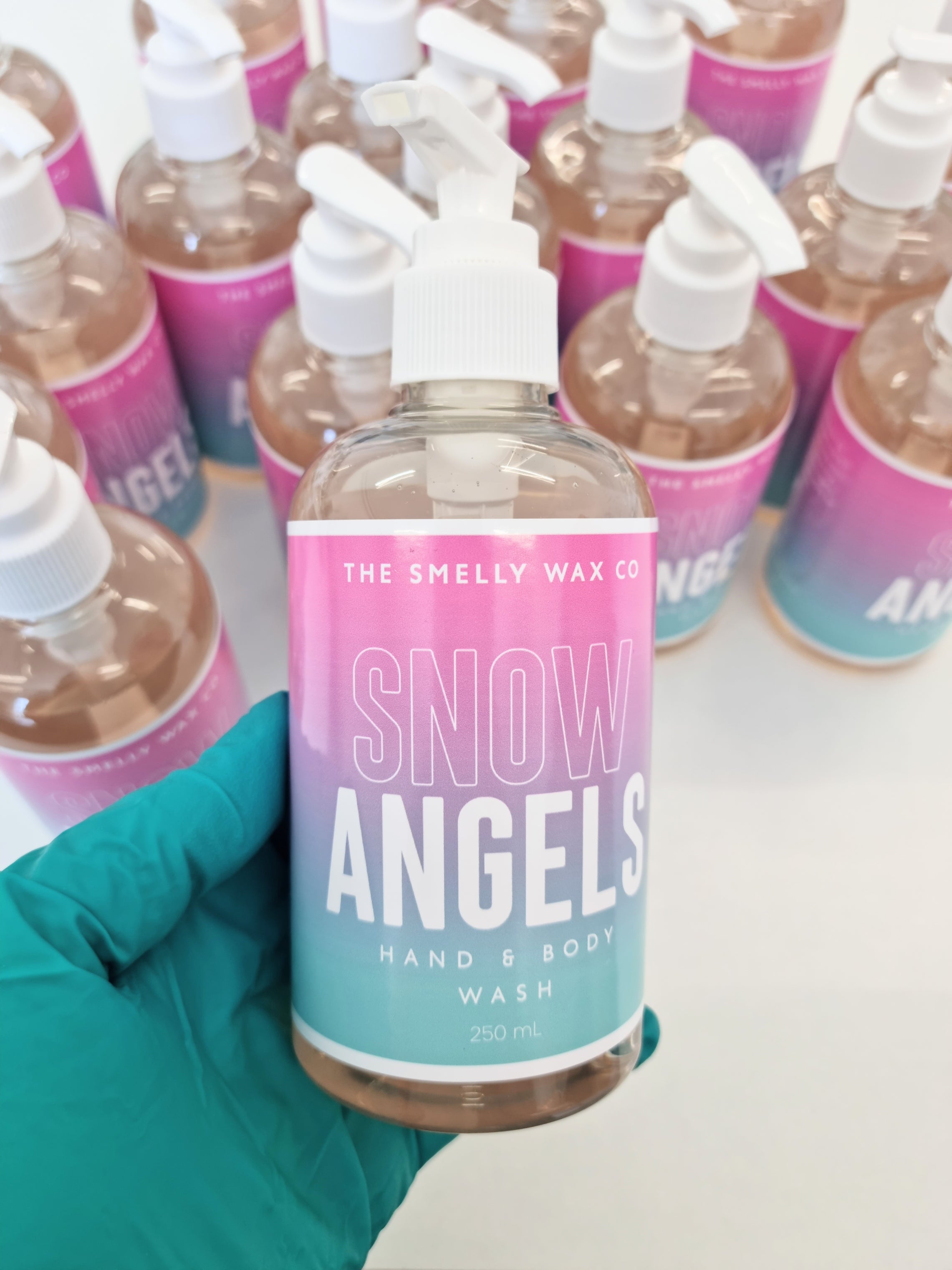 Snow angels hand and body wash in a pink and teal pump bottle by the smelly wax company