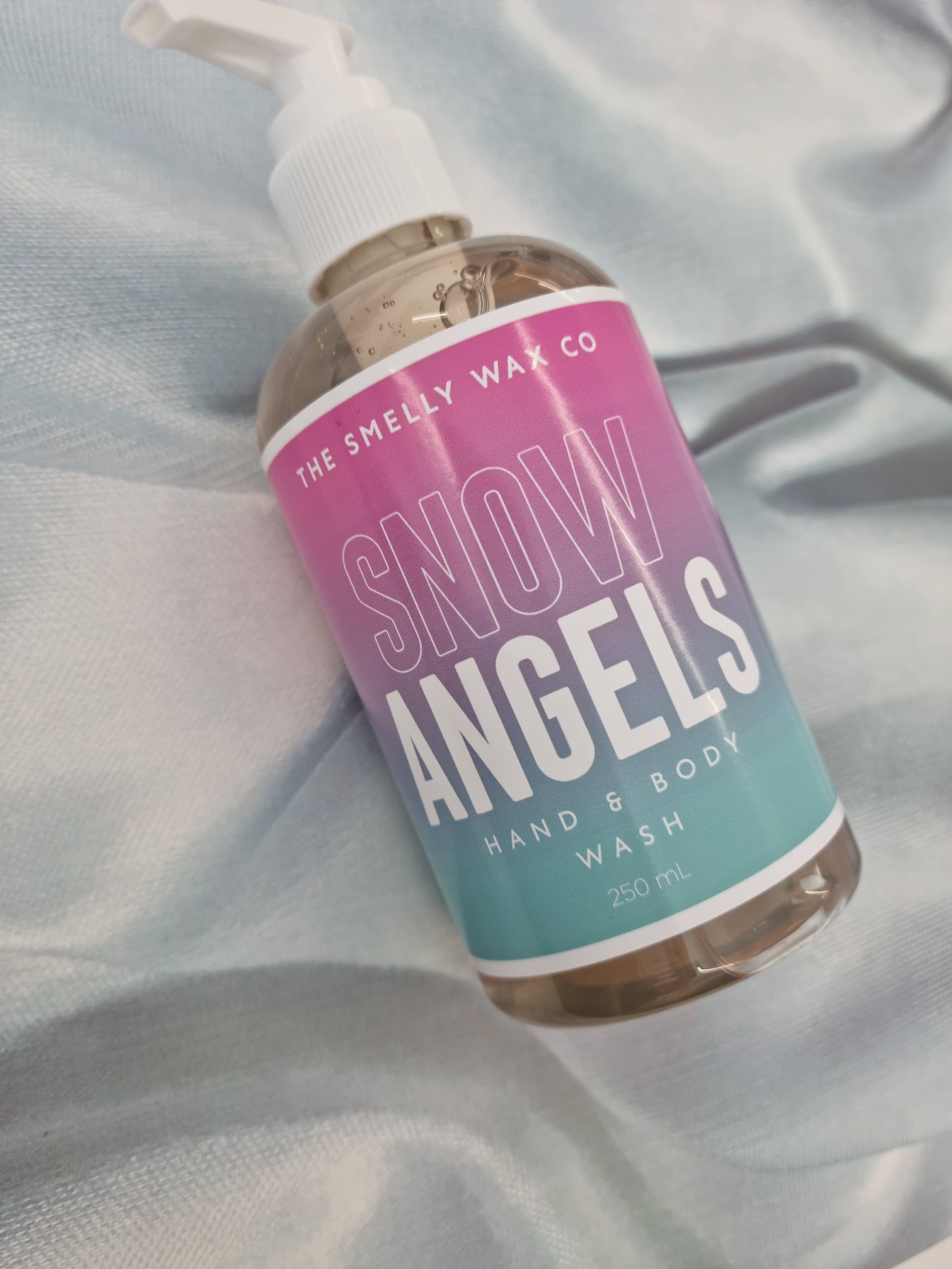 Snow angels hand and body wash in a pink and teal pump bottle by the smelly wax company